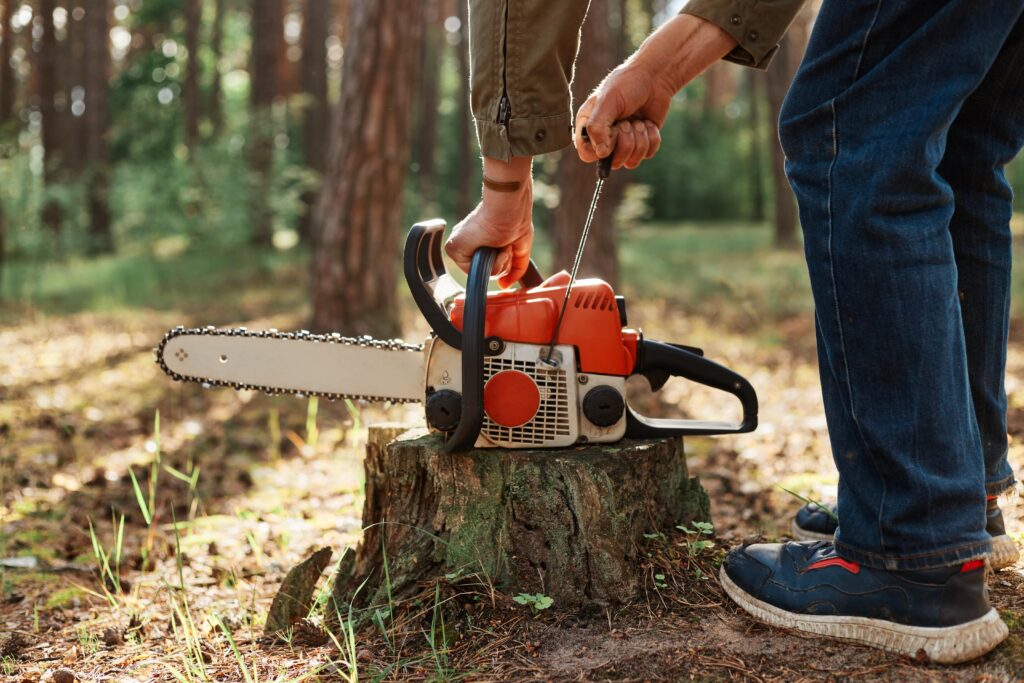 closeup-chainsaw-wooden-stump-faceless-woodsman-start-saw-min